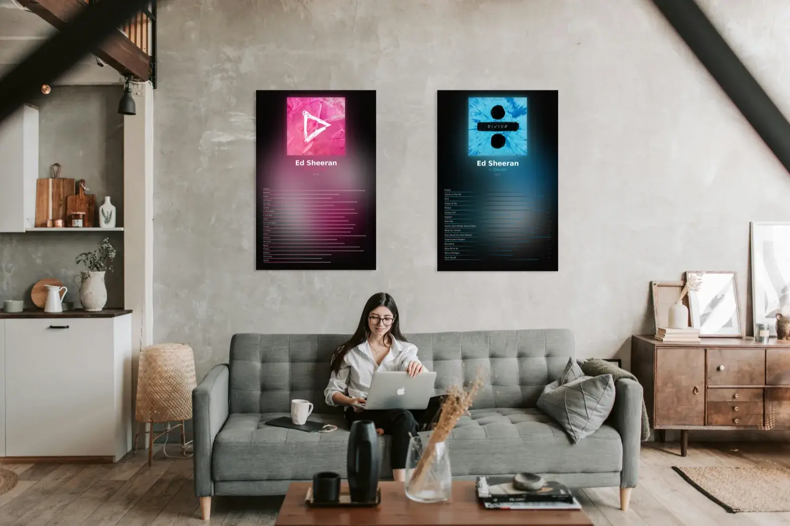 Two album art metal prints hanging above a couch in a modern loft living room